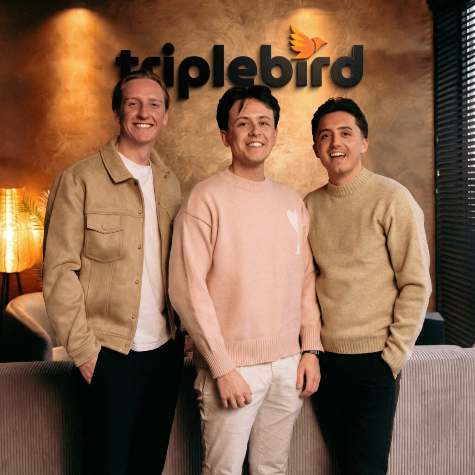 De drie oprichters van Triplebird voor het Triplebird-logo op kantoor